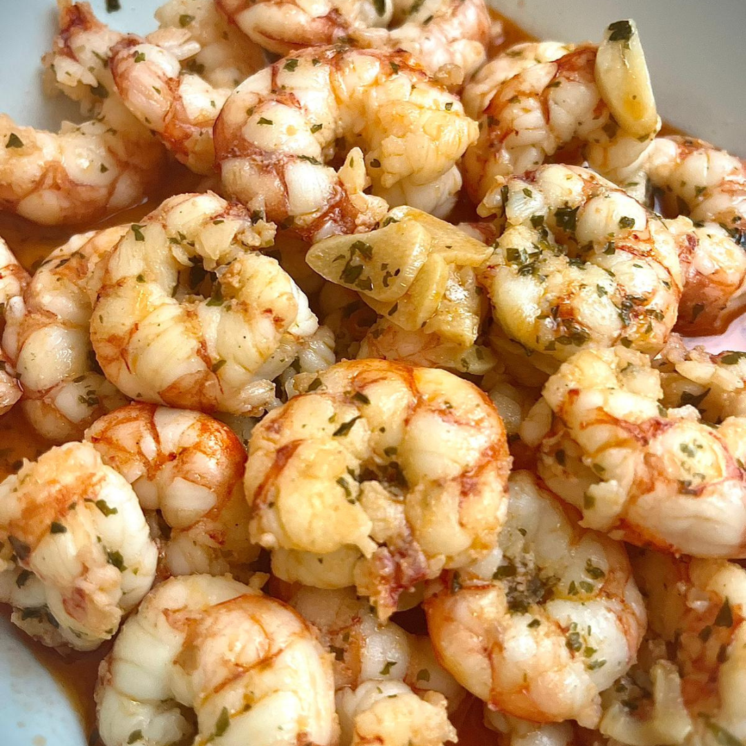 Gambas al ajillo servidas con aceite, ajo y perejil, un clásico plato español lleno de sabor.