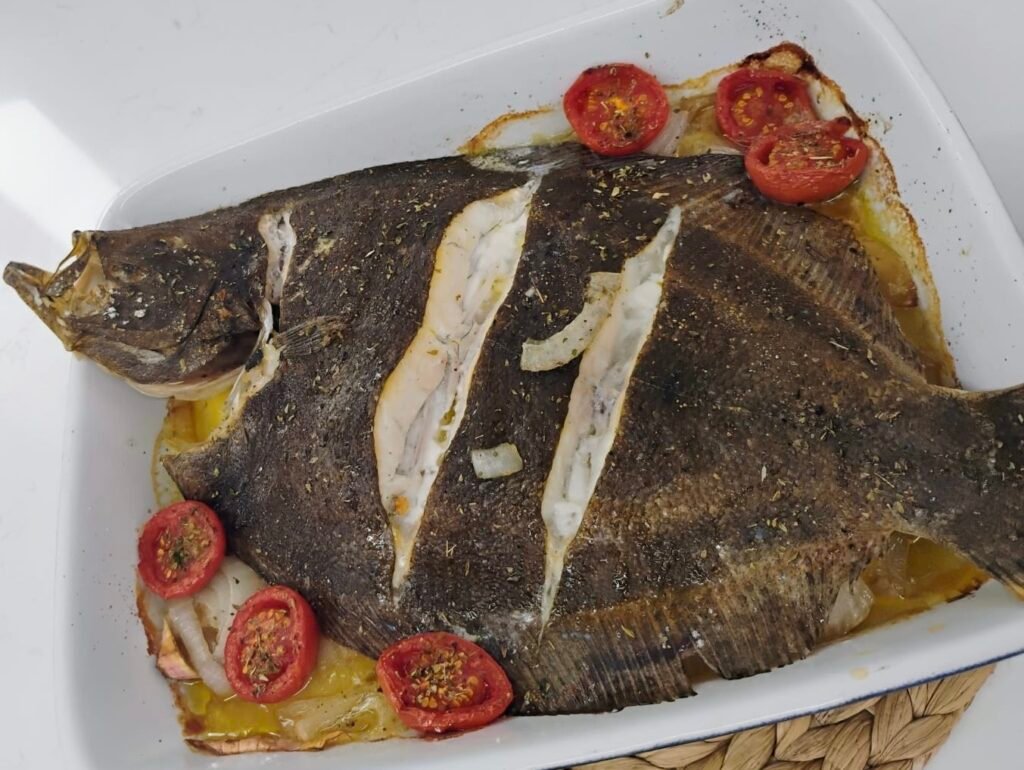Turbot sencer cuinat al forn amb llit de patates, ceba i tomàquet, recepta tradicional
