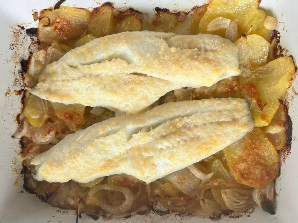 Filets de lluç al forn sobre llit de patates i ceba amb parmesà