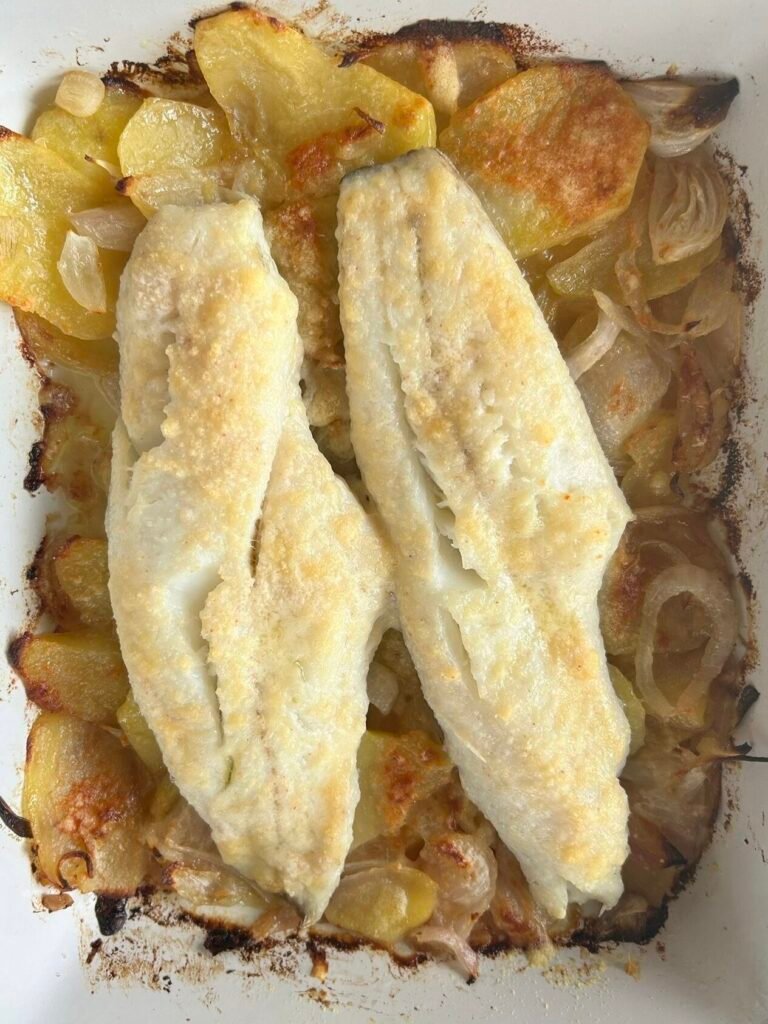 Filets de lluç al forn sobre llit de patates i ceba amb parmesà