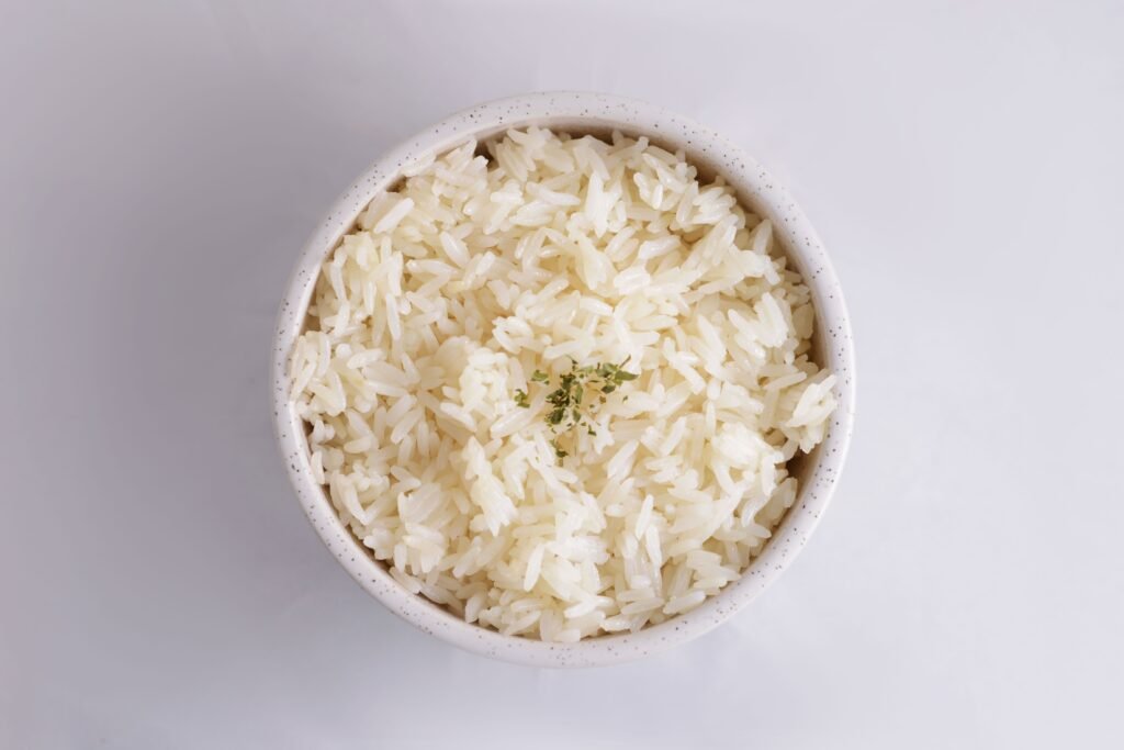 pexels-photo-8923092-8923092 Close-up of cooked white rice in a bowl, garnished with herbs, in a minimalist setup.